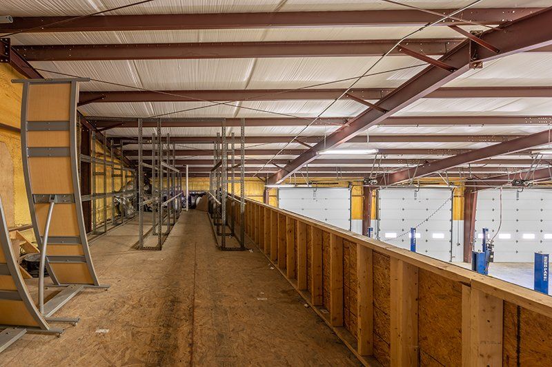 A large warehouse with a lot of wooden walls and a ceiling.
