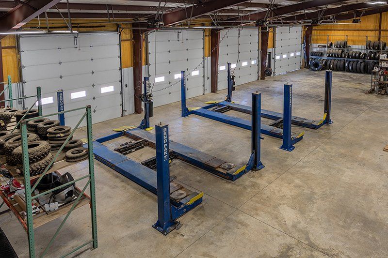 A garage with a lot of tires and a lot of lifts.