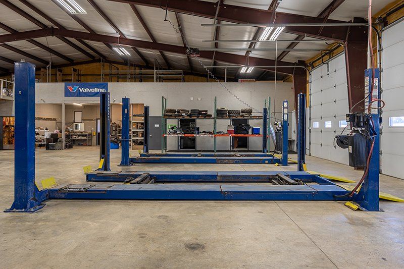 A row of blue hydraulic lifts in a garage.