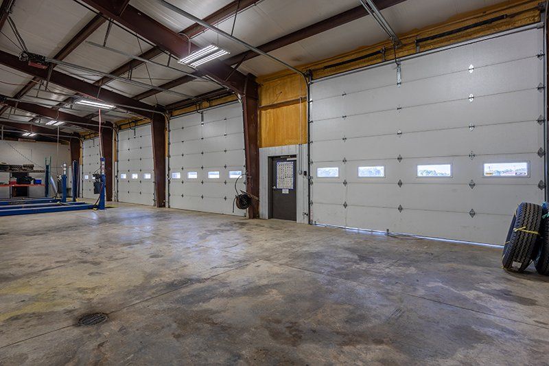 A large empty garage with a lot of garage doors.