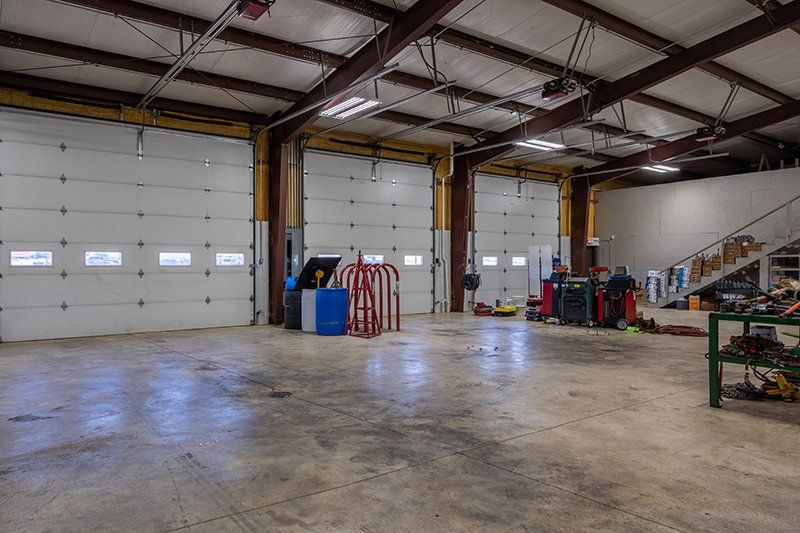 A large empty garage with a lot of garage doors.
