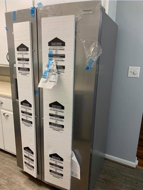 A stainless steel refrigerator is sitting in a kitchen.