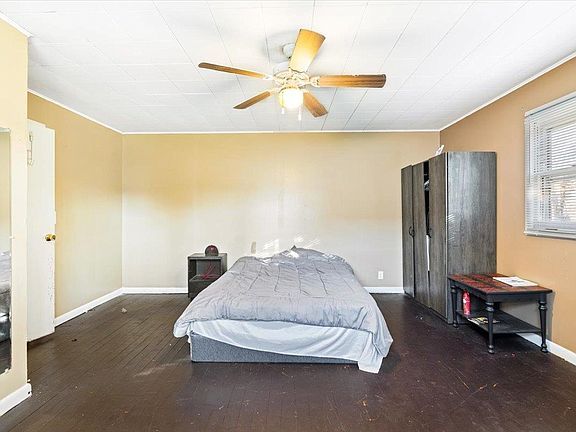 A bedroom with a bed and a ceiling fan
