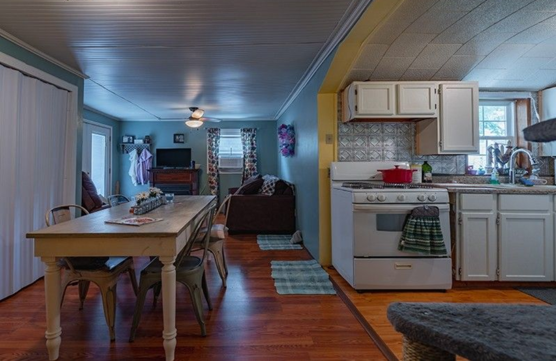 A kitchen with a table and chairs and a stove.