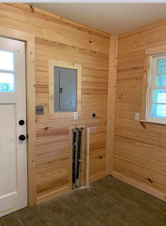 A room with wood paneling , a door , and a window.