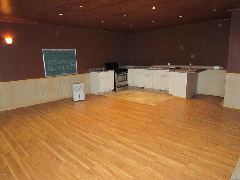 An empty room with wooden floors and a chalkboard on the wall