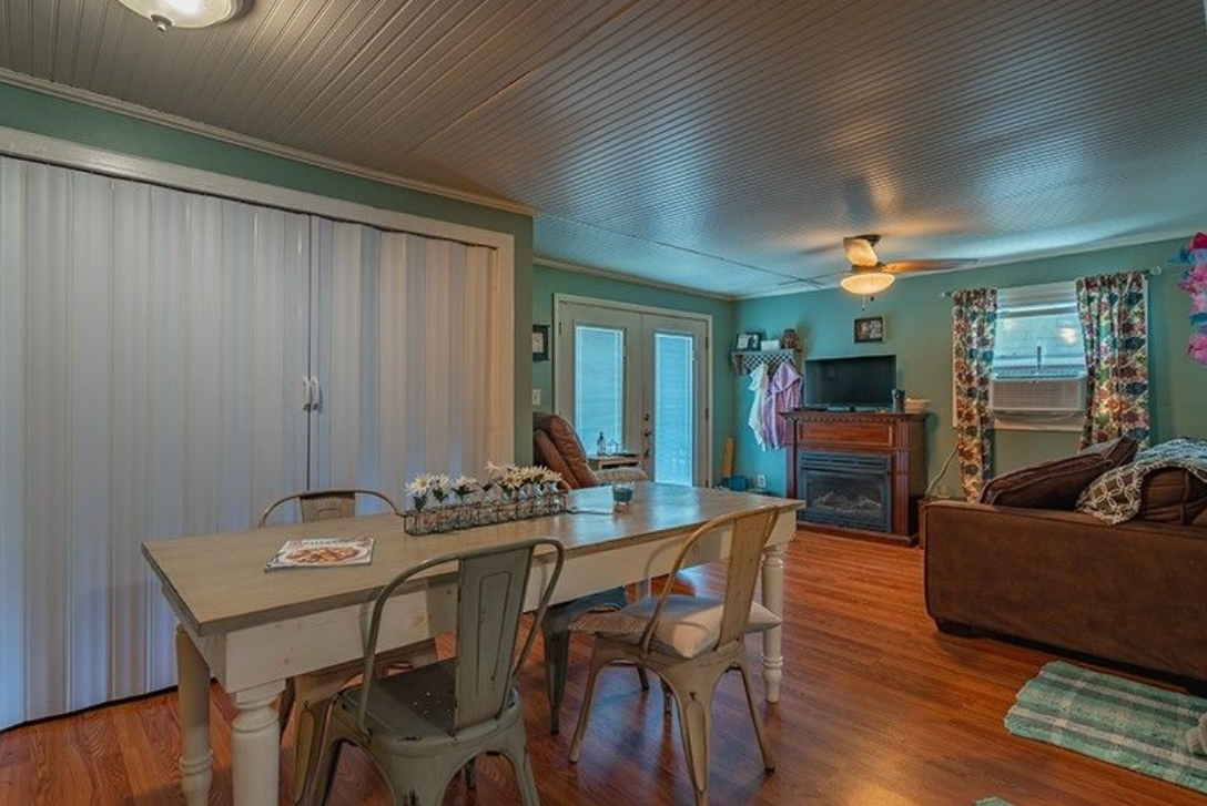 A living room with a table and chairs and a fireplace.
