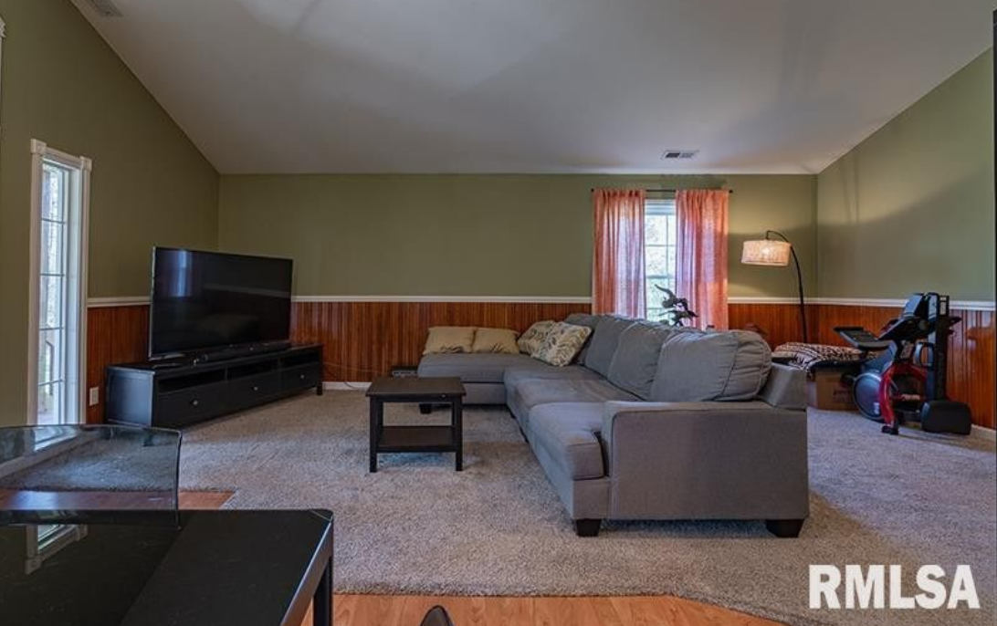 A living room with a couch , table , and television.
