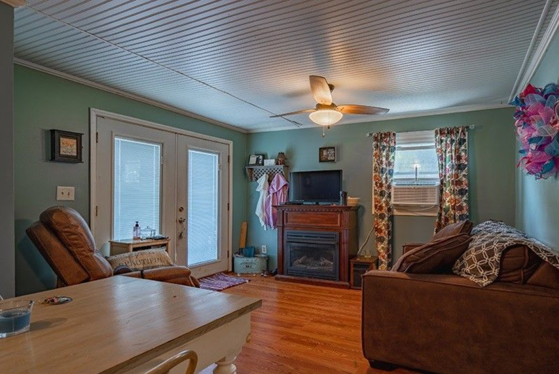 A living room with a couch , chair , table and fireplace.