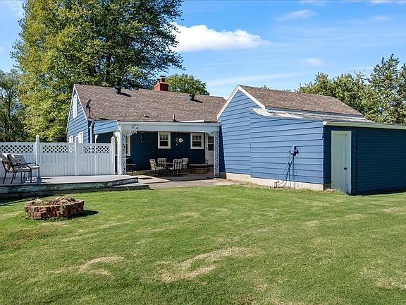 A blue house with a green shed in the backyard.