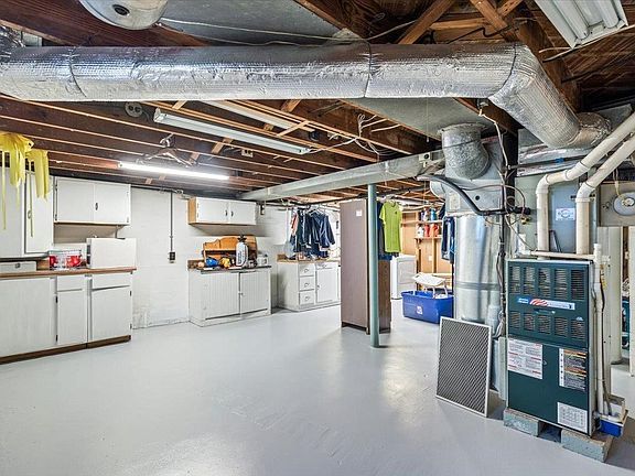 A basement with a kitchen and a furnace.