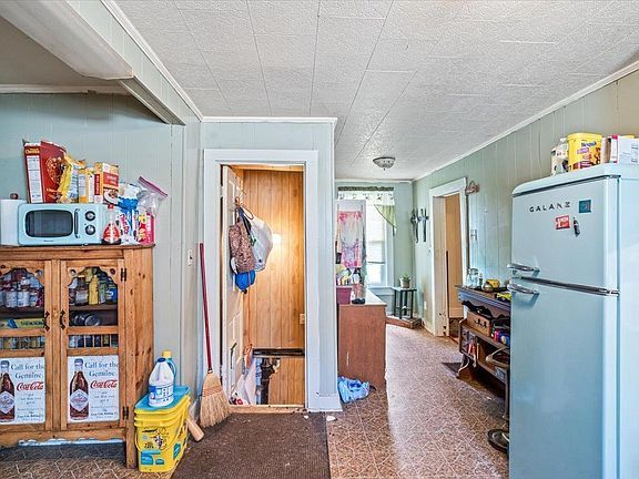 A kitchen with a refrigerator and a microwave.