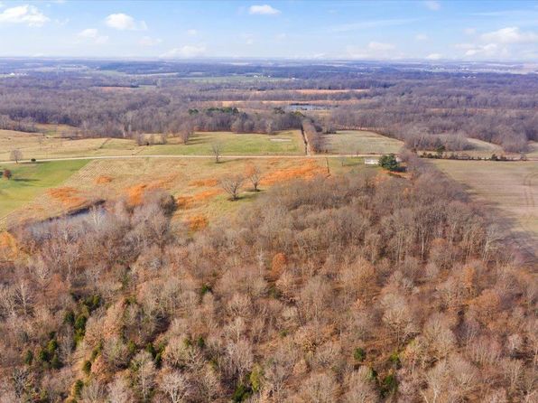 An aerial view of a lush green field surrounded by trees.