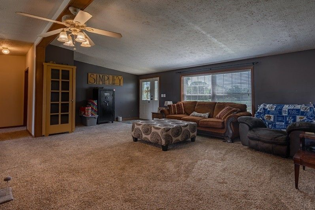 A living room filled with furniture and a ceiling fan.