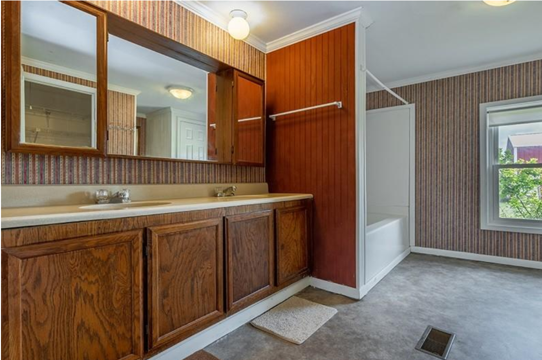 A bathroom with a sink , mirror , and bathtub.