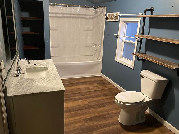 A bathroom with a toilet , sink , and bathtub.