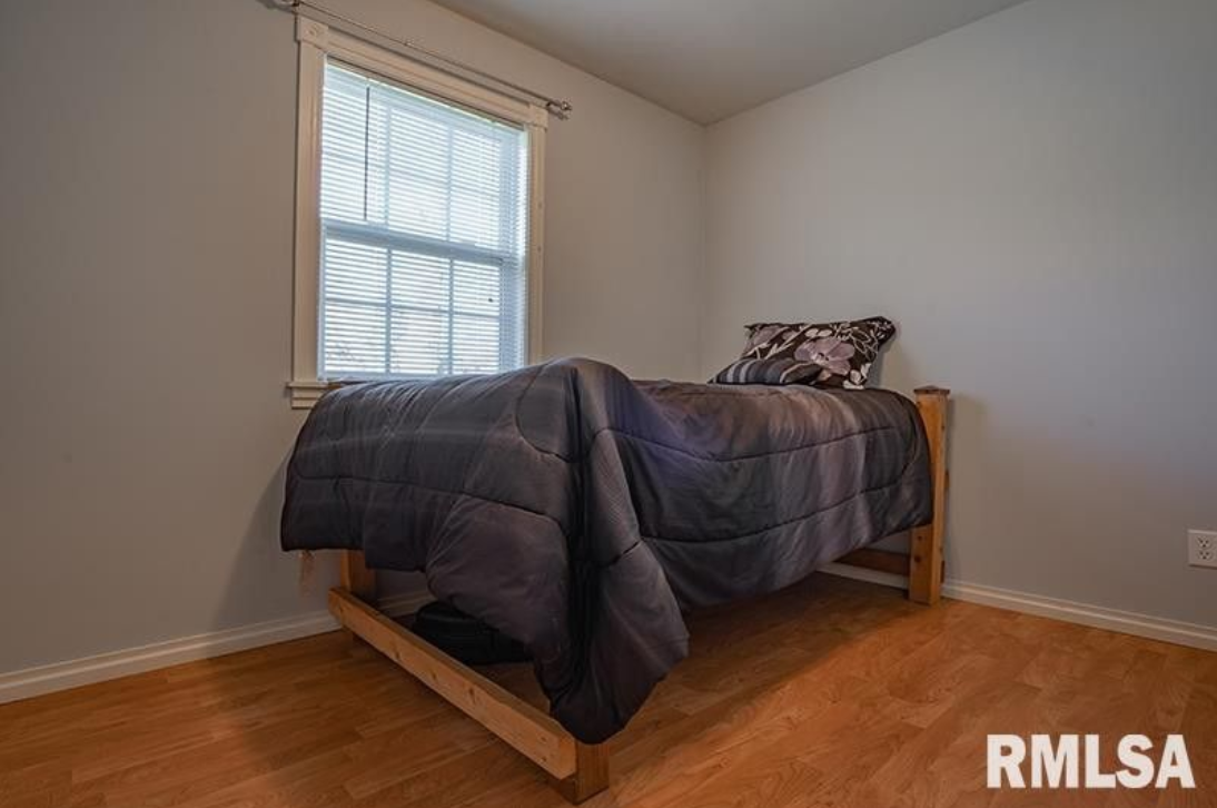 A bedroom with a single bed and a window.