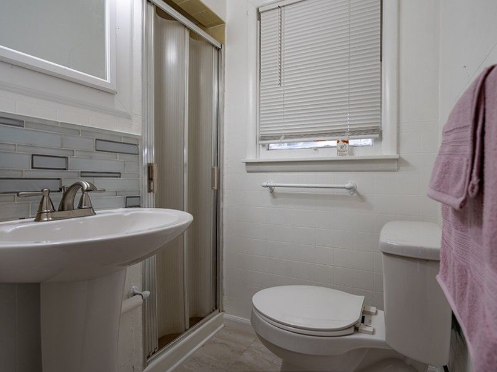 A bathroom with a sink , toilet and shower.