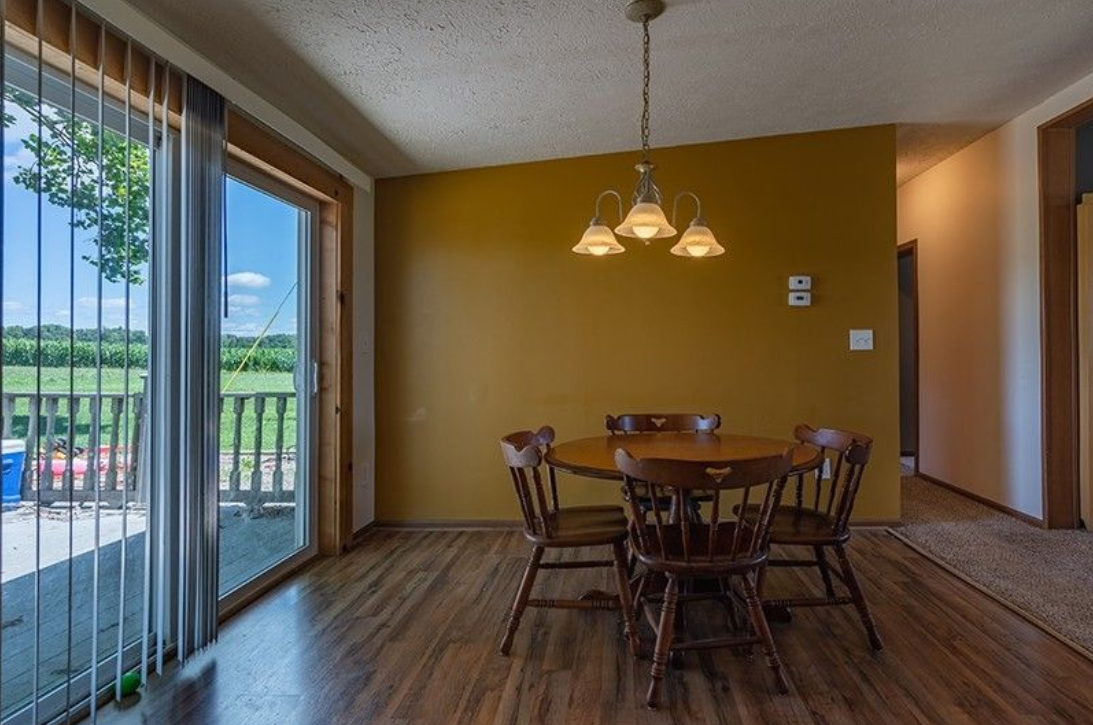 A dining room with a table and chairs and a sliding glass door