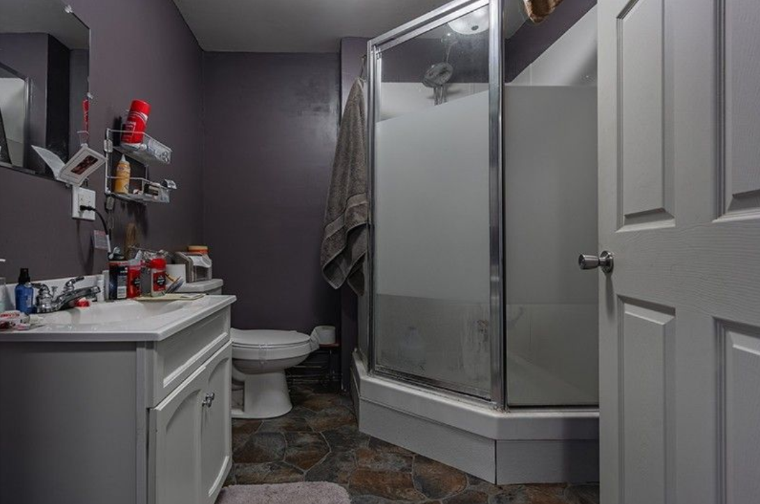 A bathroom with a sink , toilet , shower and mirror.