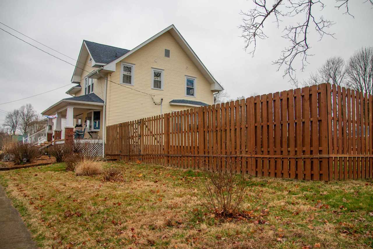 A house with a wooden fence in front of it.