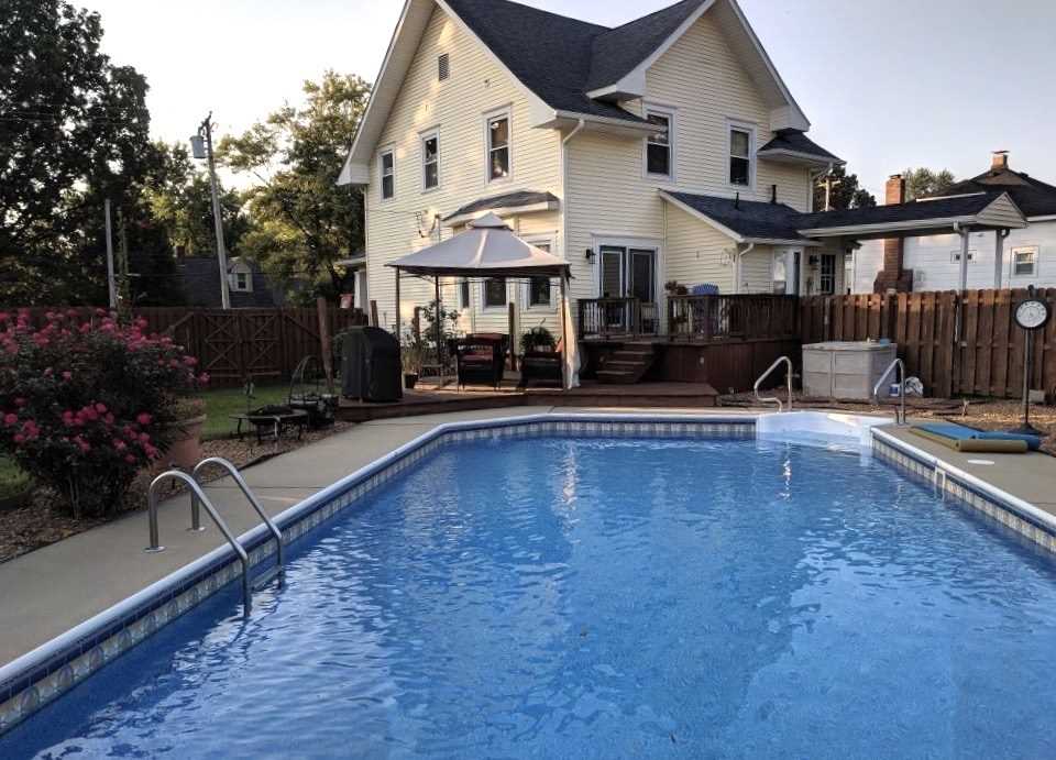A large house with a swimming pool in front of it