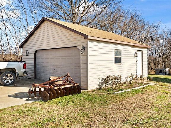 A white truck is parked in front of a garage.