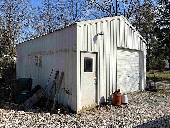 A white garage with a garage door and a window.