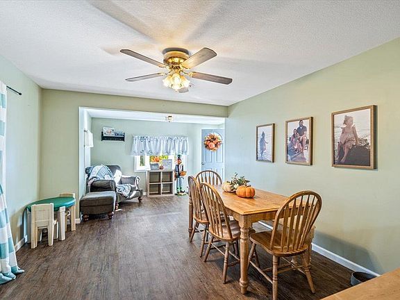 A dining room with a table and chairs and a ceiling fan.