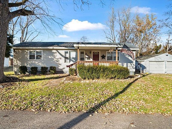 A house with a large lawn and a garage is for sale.