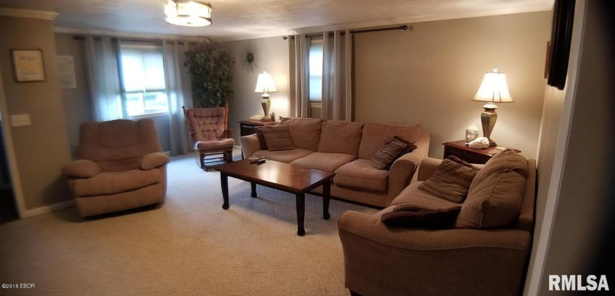 A living room with a couch , chairs , and a coffee table.