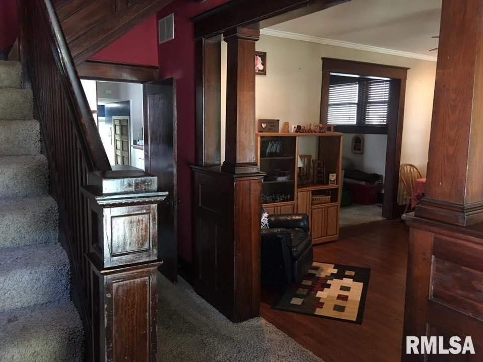 A living room with a staircase and rmlsa written on the bottom