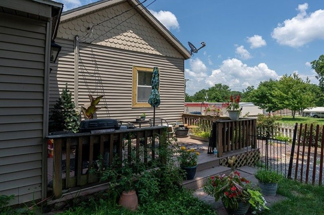 A house with a deck and a fence in front of it.
