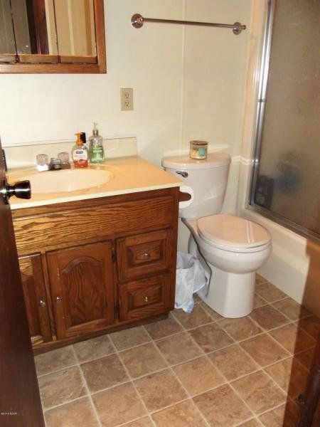 A bathroom with a toilet a sink and a mirror