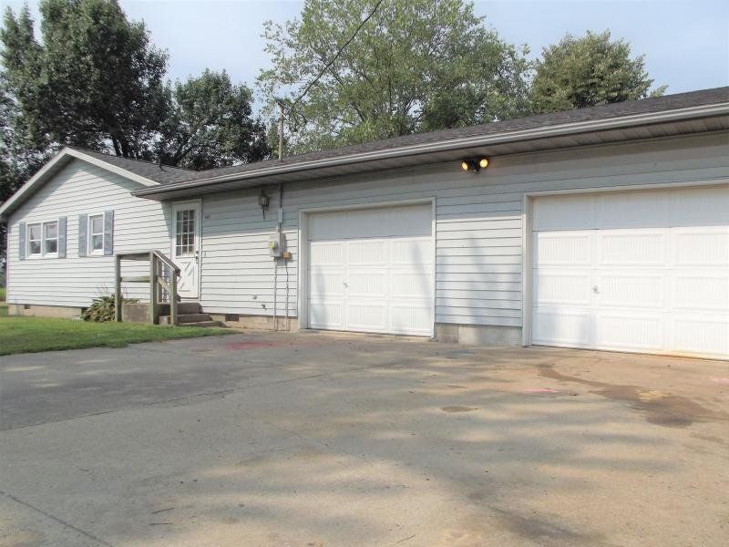 A white house with two garage doors in front of it
