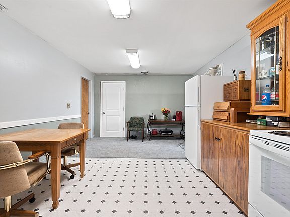 A kitchen with a table and chairs and a refrigerator.