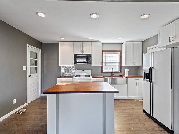 A kitchen with white cabinets and a large island in the middle.