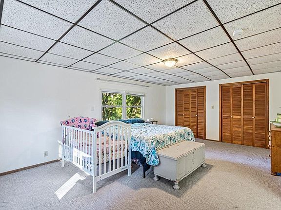 A bedroom with two beds and a crib in it.