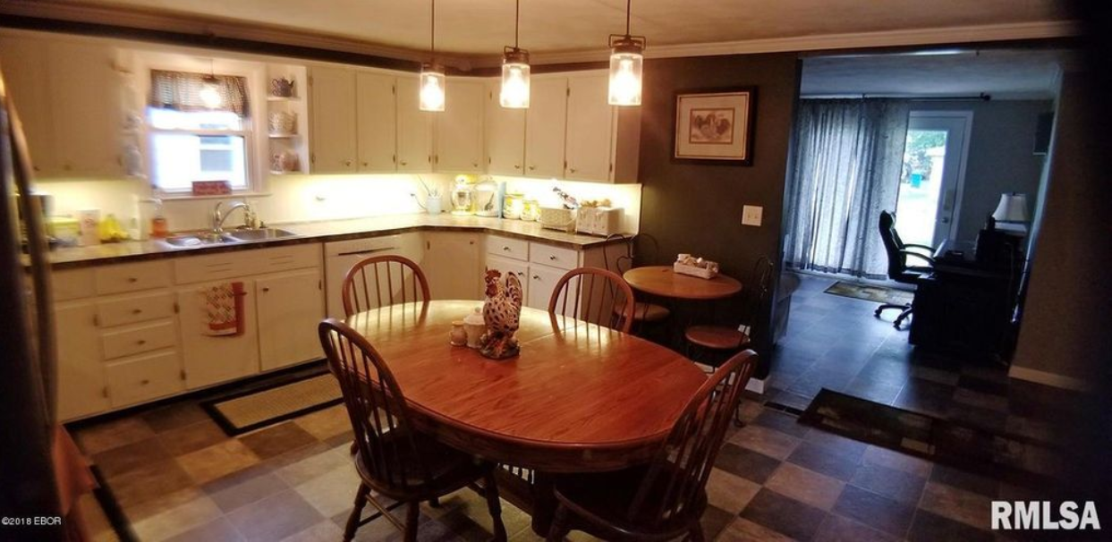 A kitchen with a table and chairs in it