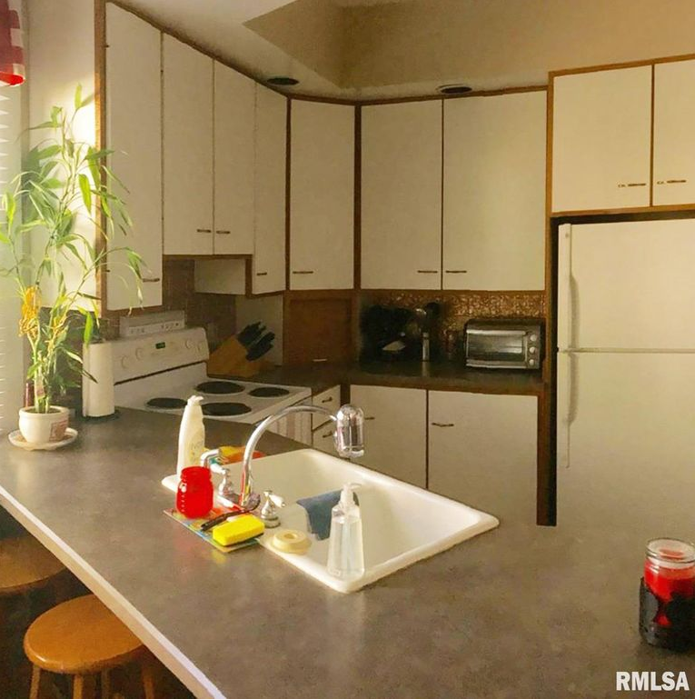 A kitchen with a sink and a refrigerator from rmlsa