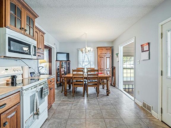 A kitchen with a table and chairs and a microwave.