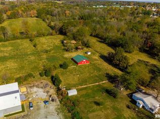 An aerial view of a farm with a red barn in the middle of a field.