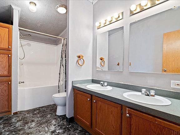 A bathroom with two sinks , a toilet , and a bathtub.