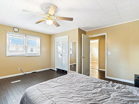 A bedroom with a bed and a ceiling fan.