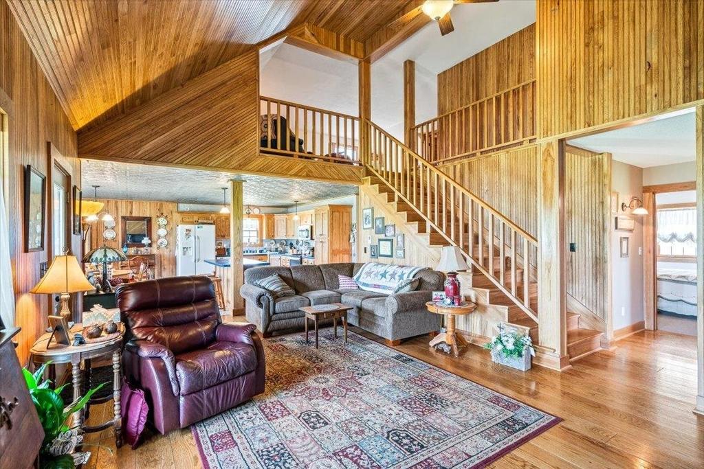 A living room filled with furniture and a staircase in a house.
