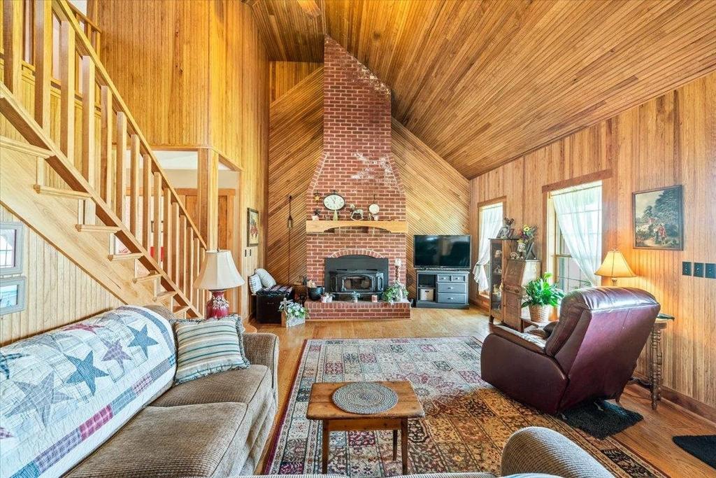 A living room with a couch , chair , table and fireplace.