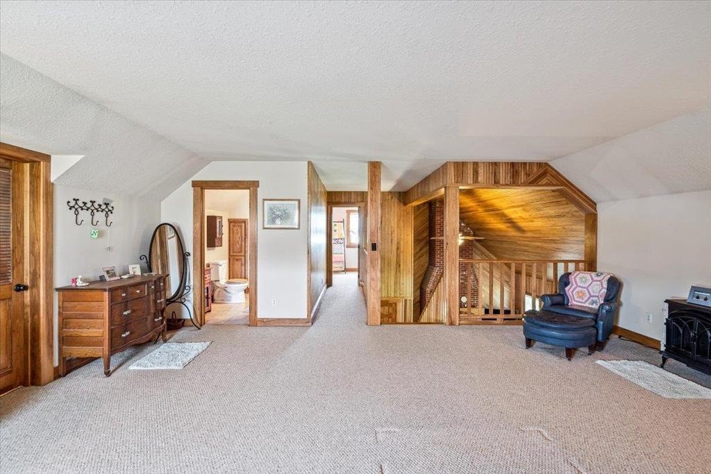 A living room with a chair , dresser , and mirror.