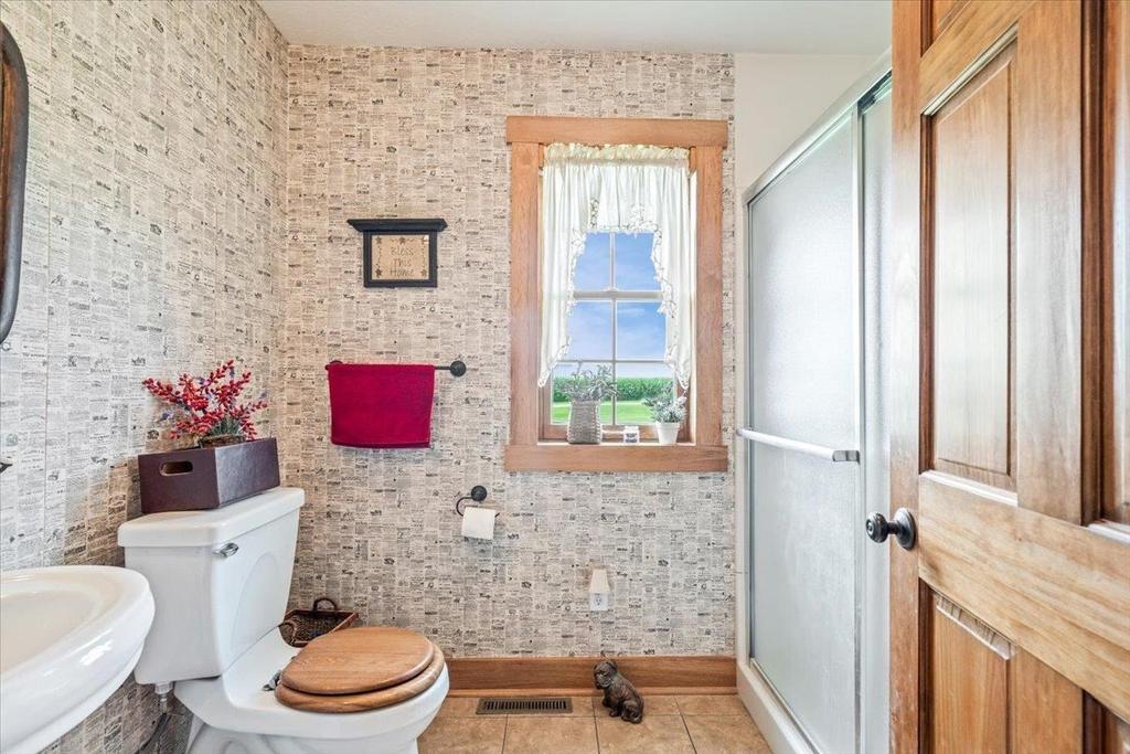 A bathroom with a toilet , sink and shower.
