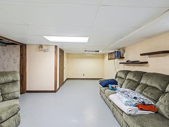 A living room with a couch and two chairs in it.