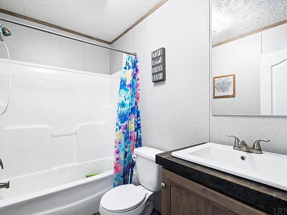 A bathroom with a toilet , sink , bathtub and shower.